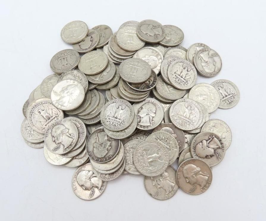 Pile of silver US quarters on a white surface.