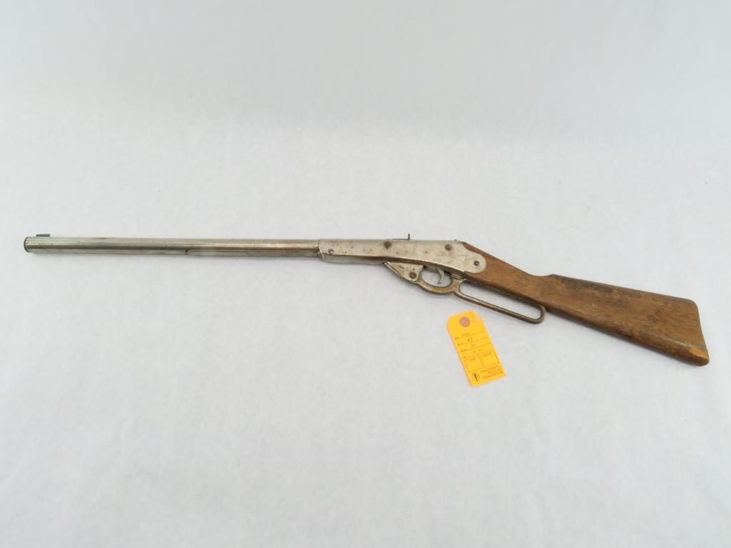 BB gun with silver barrel and brown wooden stock, against a white backdrop.