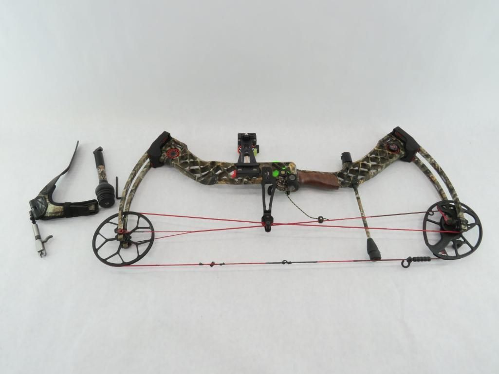 Camouflage compound bow with accessories on a white surface.