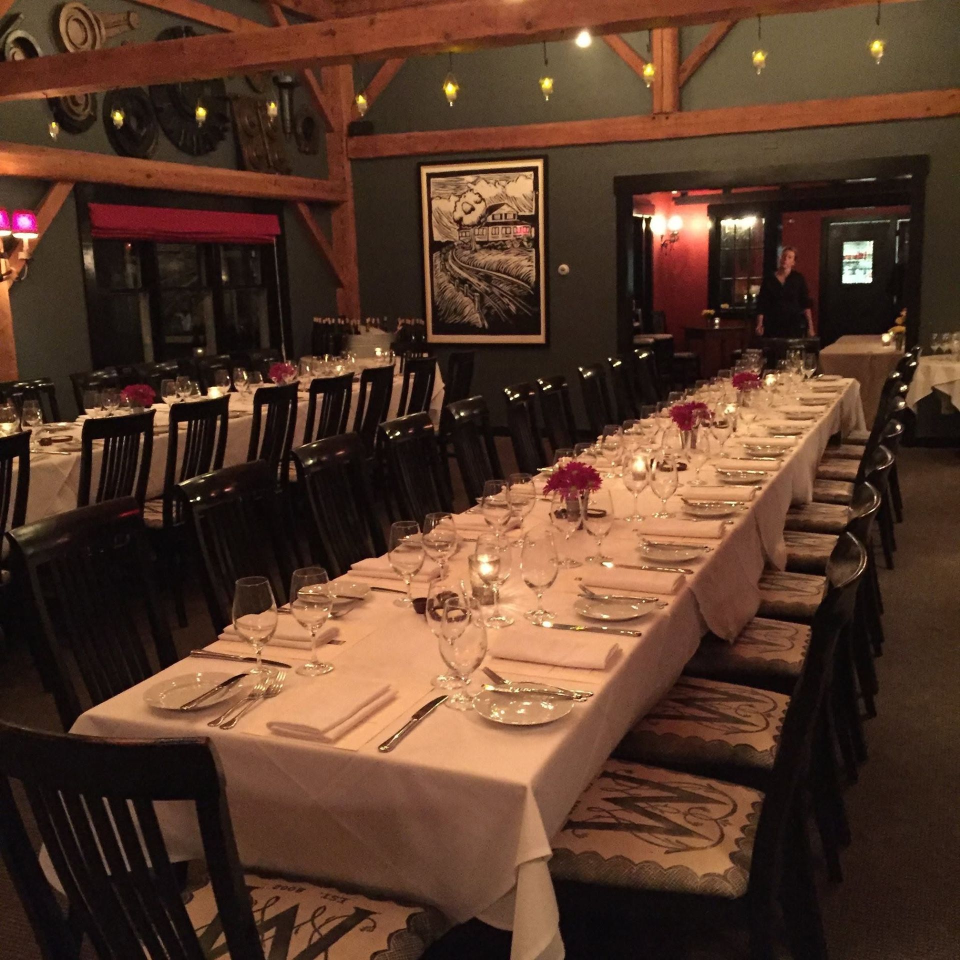 Elegant dining room with a long white-tablecloth banquet table set with glassware and candles