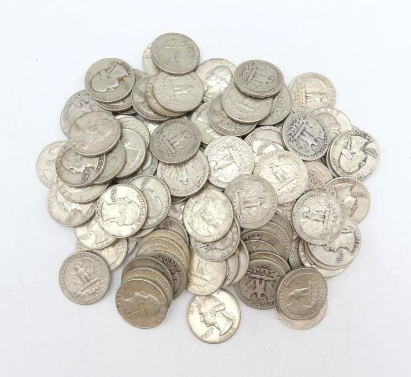 Pile of silver quarters on a white surface, displaying coin details.