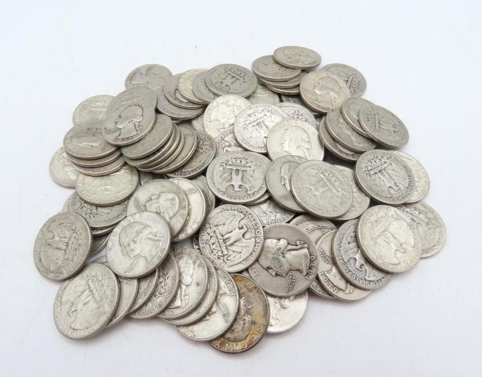 Pile of silver coins, mostly quarters, scattered on a white surface.