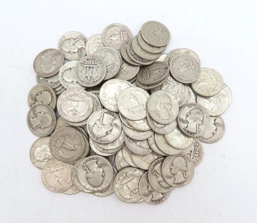 Pile of silver US quarters on a white surface.
