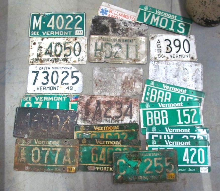 Collection of old, weathered Vermont license plates in various conditions and styles.