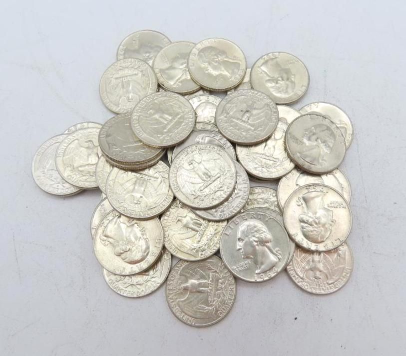 Pile of silver U.S. quarter coins on a light-colored surface.