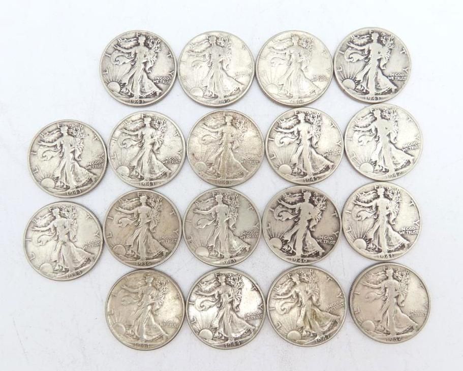 Twenty silver Walking Liberty half dollars arranged on a white surface.