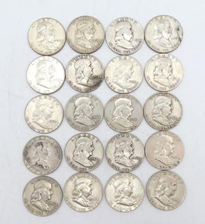 Twenty silver Franklin half dollar coins arranged on a surface.