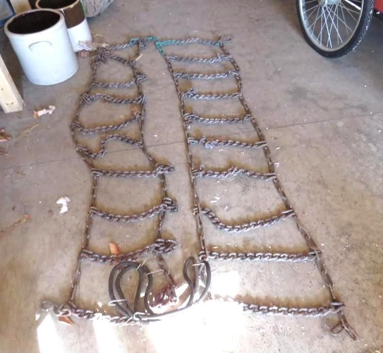 Snow chains on a concrete floor near a wheel.
