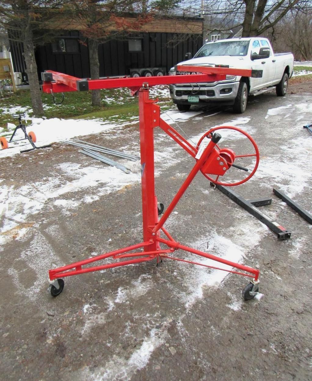 Red drywall lift on wheels outdoors.