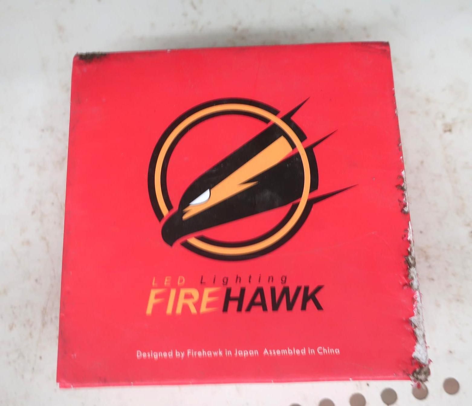 Red box with Firehawk LED Lighting logo featuring a hawk head and text; designed in Japan, assembled in China.