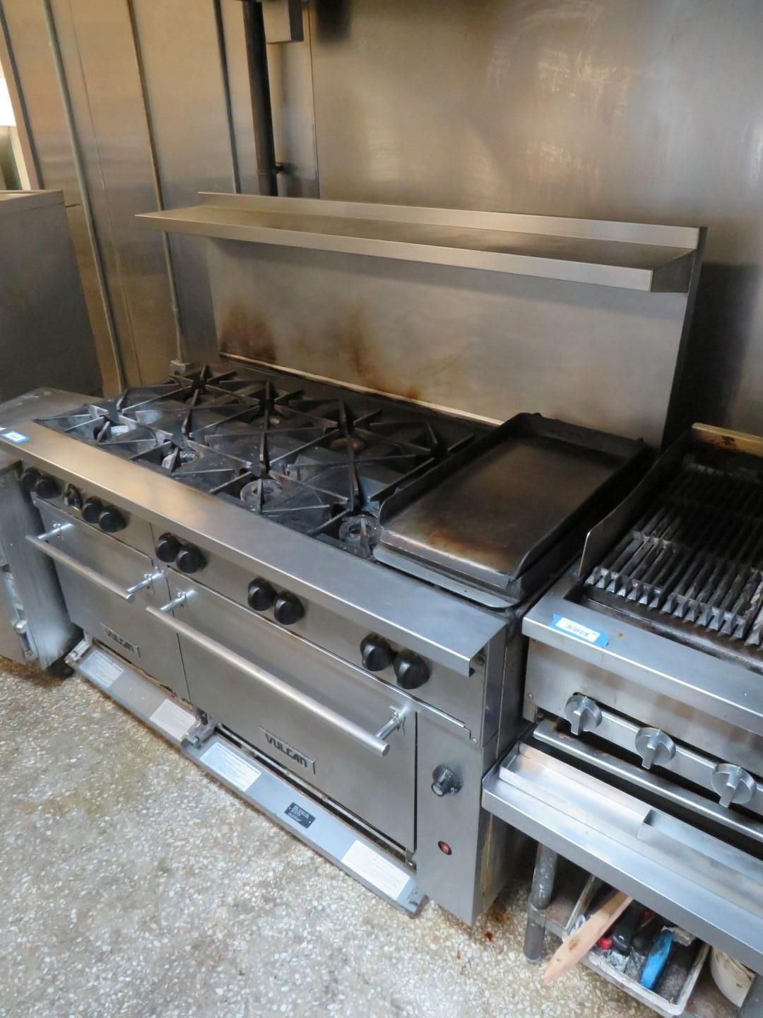 Commercial kitchen stove with burners, griddle, and oven. Stainless steel.
