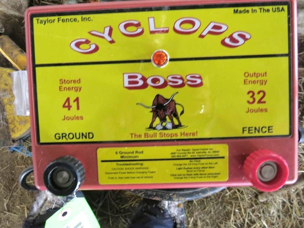 Red and yellow electric fence energizer with the word
