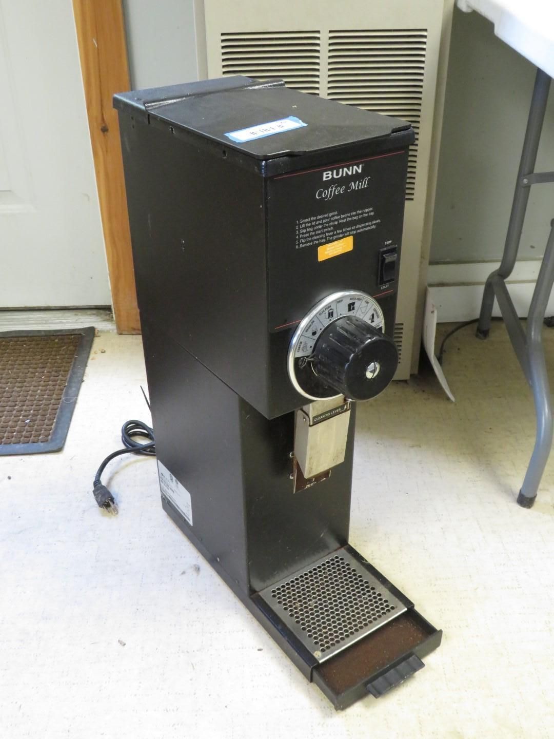Black commercial coffee grinder with adjustable grind size dial, power switch, and tray.