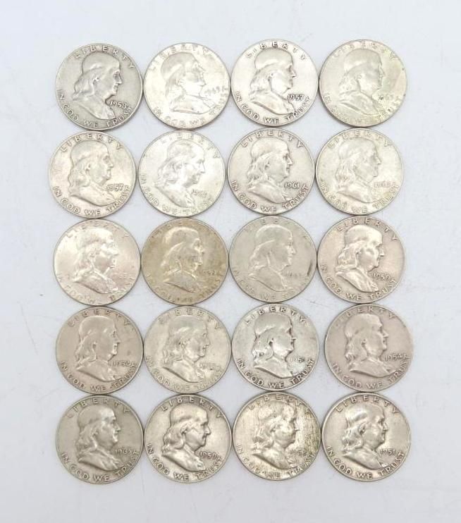 Twenty silver Franklin half dollar coins arranged on a white surface.