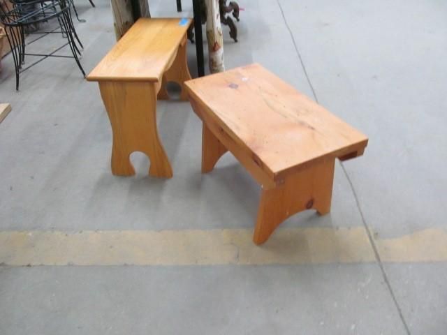 Two small, light-wood benches with curved legs, sitting on a gray floor.