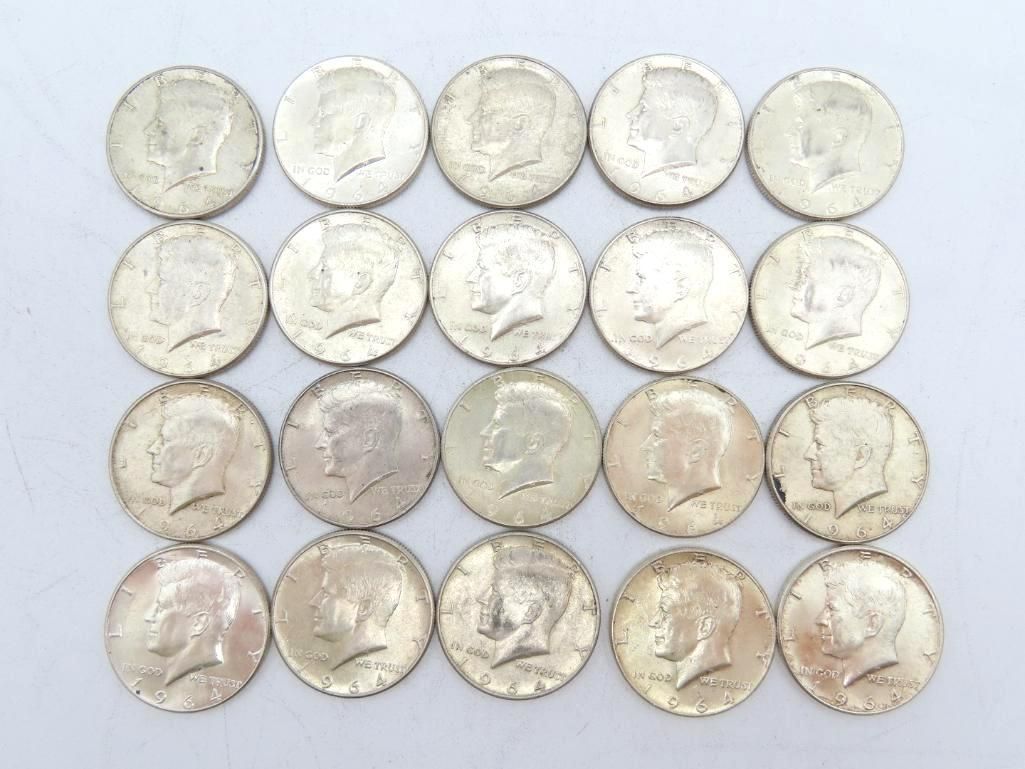 Twenty silver Kennedy half dollars arranged in a rectangular grid on a white surface.