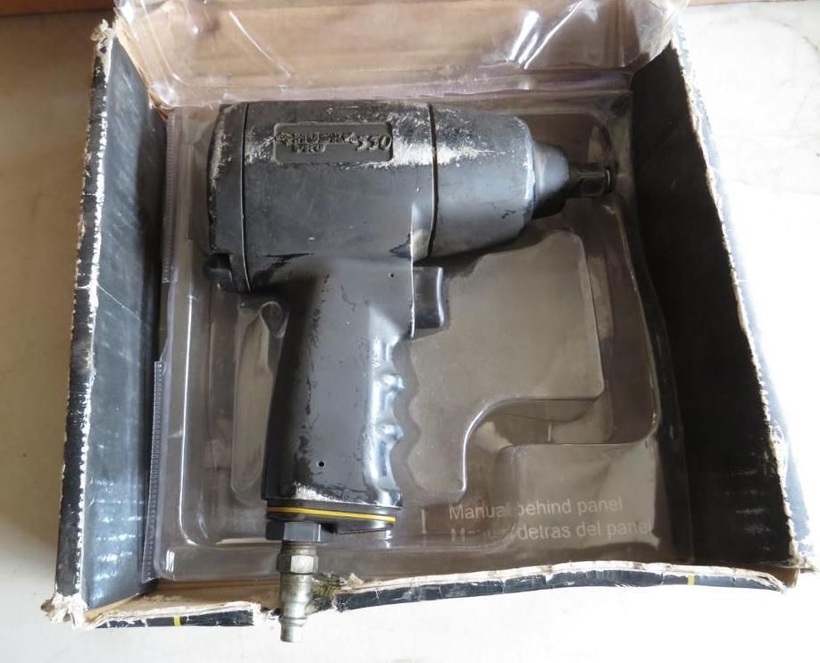 Air impact wrench in a cardboard box with plastic molding.