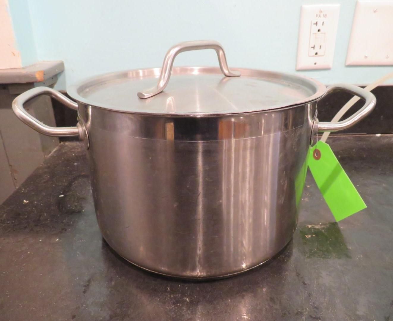 Stainless steel cooking pot with lid on a dark surface.