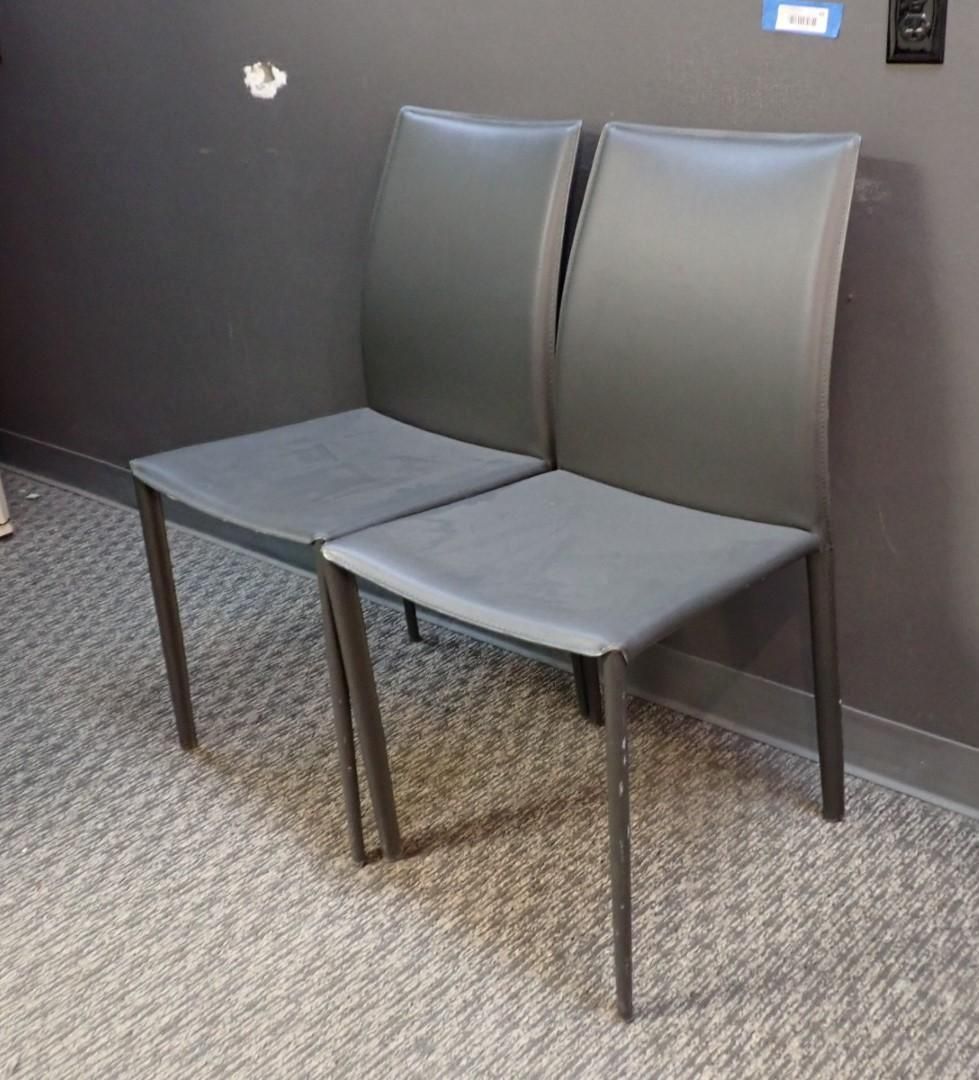 Two gray chairs against a dark wall and on a carpeted floor.