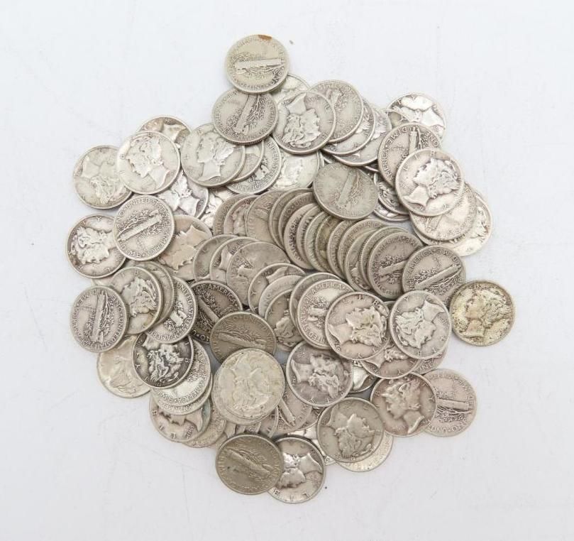Pile of silver nickels, likely old, scattered on a white surface.