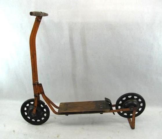 An orange, antique scooter with wooden platform and metal wheels.