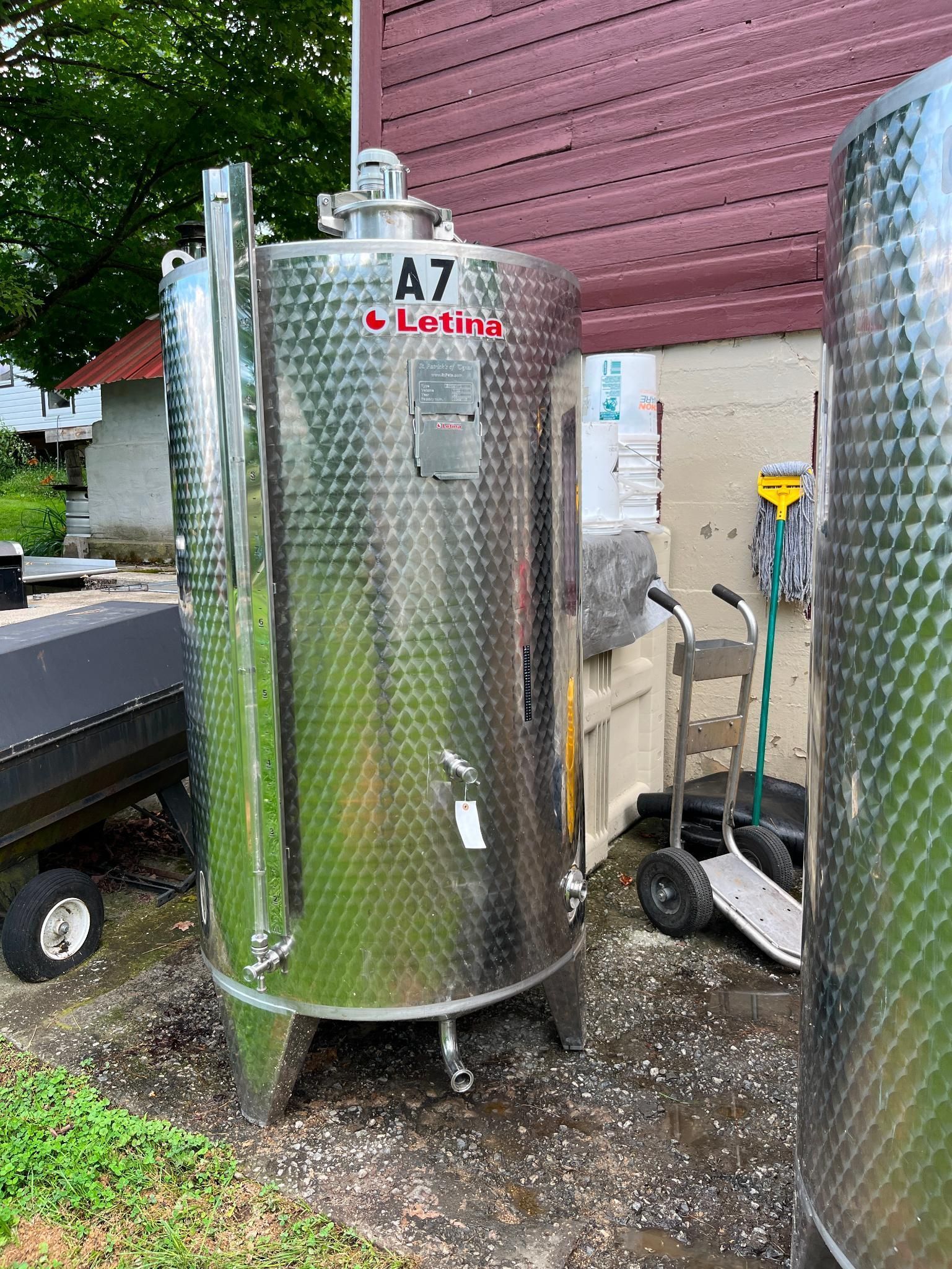Stainless steel industrial tank labeled