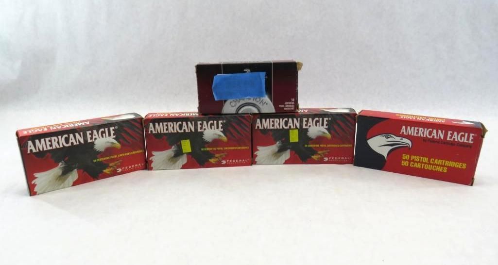 Five boxes of American Eagle ammunition, in front of a blue item and a dark red box.