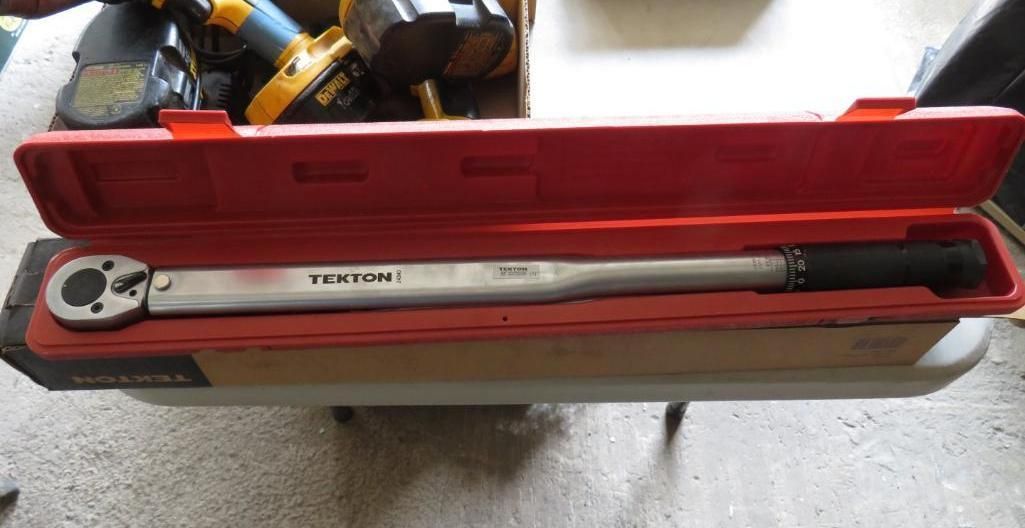 A long, silver Tekton torque wrench inside an open red case.