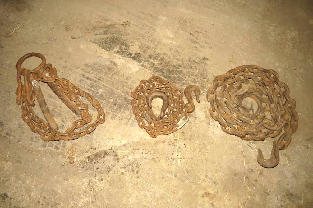 Three metal chains on a textured beige surface.