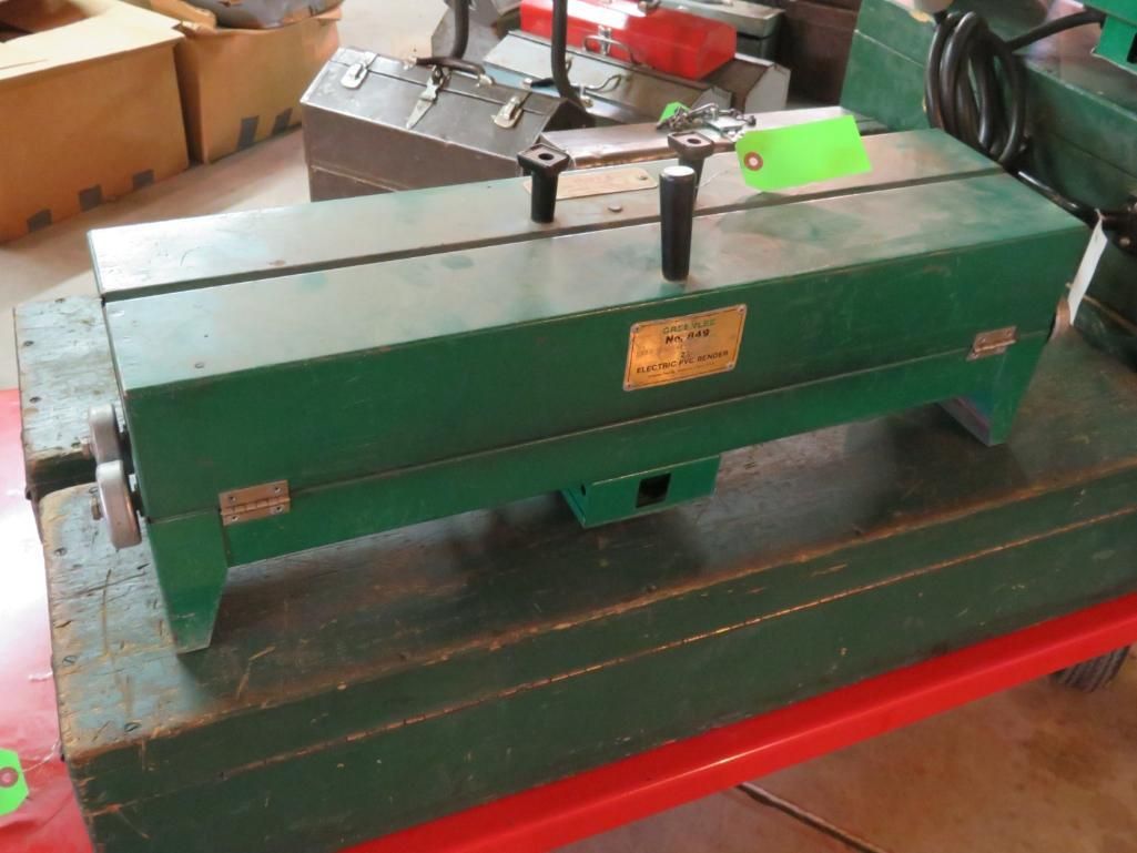 Green metal rectangular machine with two black handles.