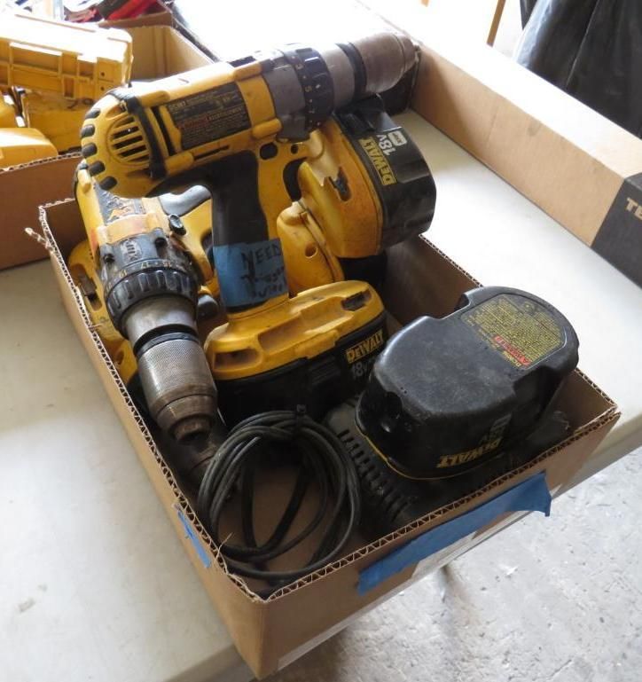 A cardboard box filled with yellow and black DeWalt power drills, batteries, and a charger.