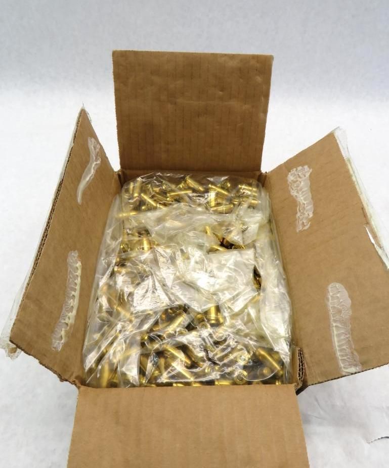 Cardboard box open to reveal a large quantity of brass-colored cabinet pulls, packed in plastic.