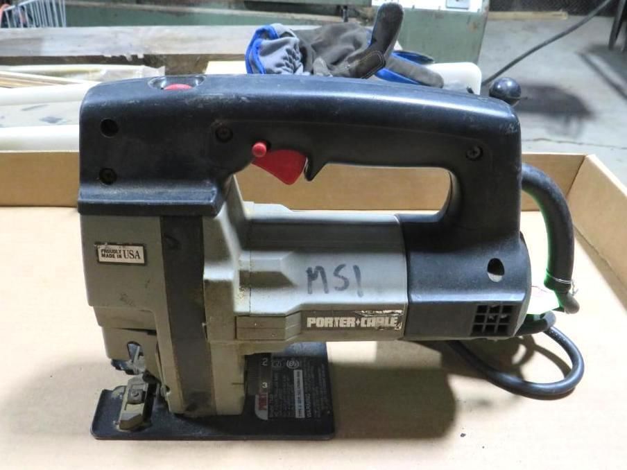 Black and gray Porter-Cable jigsaw tool with red switch, on a wooden surface.