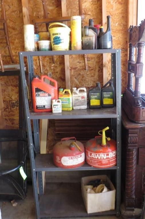 Metal shelf holding various containers in a wooden shed.
