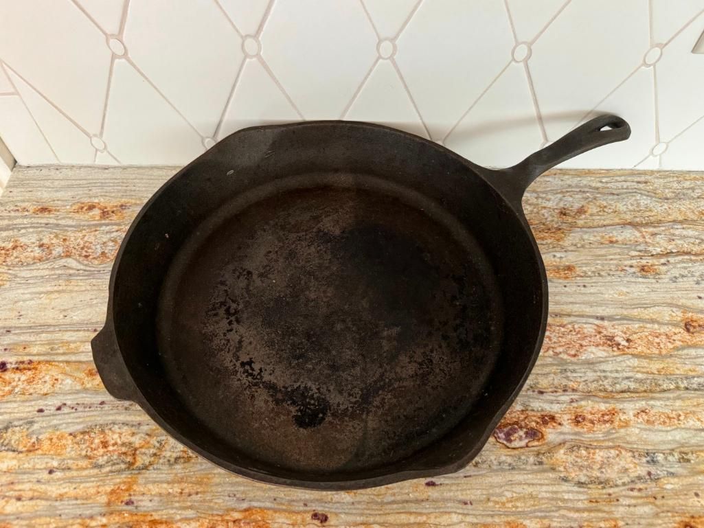 Black cast iron skillet on a countertop with a beige and brown pattern.