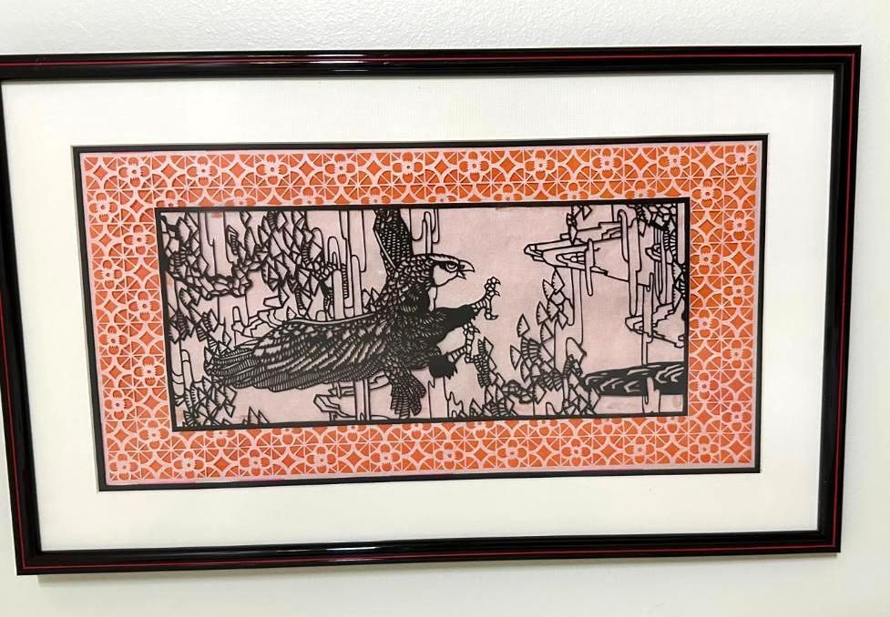 Black and white bird art with coral patterned border in a framed display.