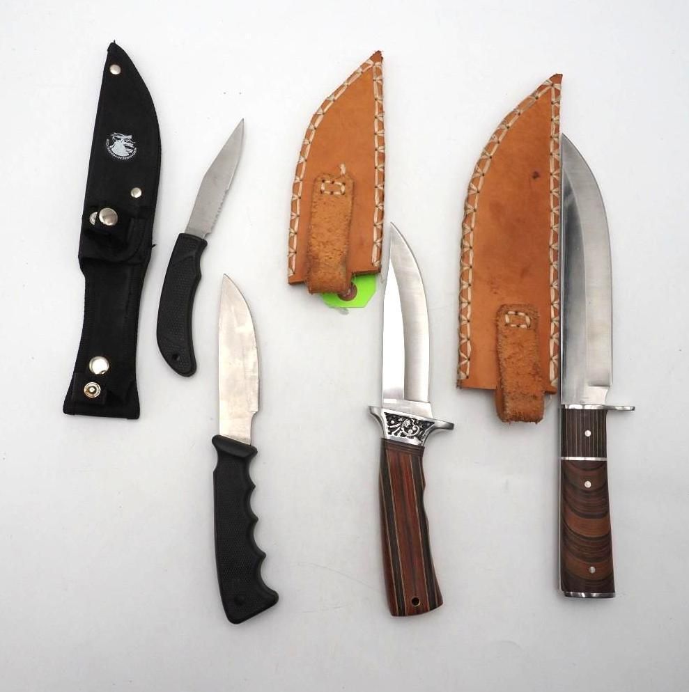 Five knives and sheaths arranged on a white background, including black, silver, and brown handles.
