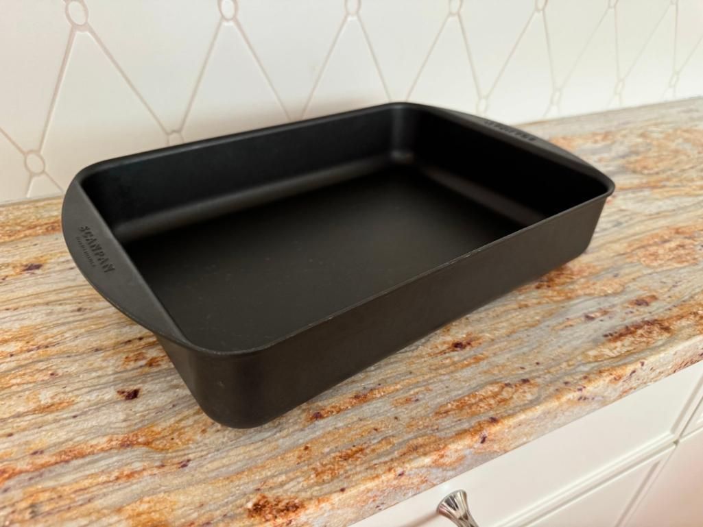 Black rectangular baking pan on a speckled countertop near a white backsplash.