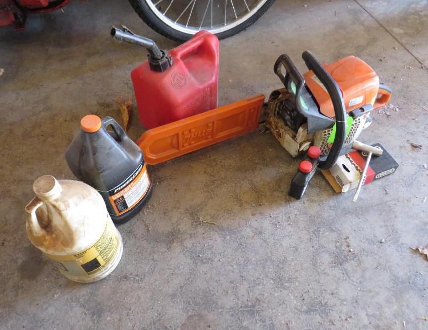 Chainsaw, gas can, oil containers, and chainsaw bar on concrete surface.