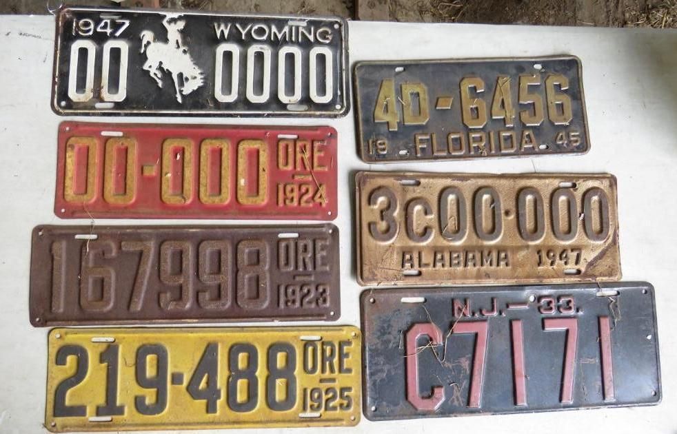 Collection of vintage license plates from various states: Wyoming, Florida, Oregon, Alabama, and New Jersey.
