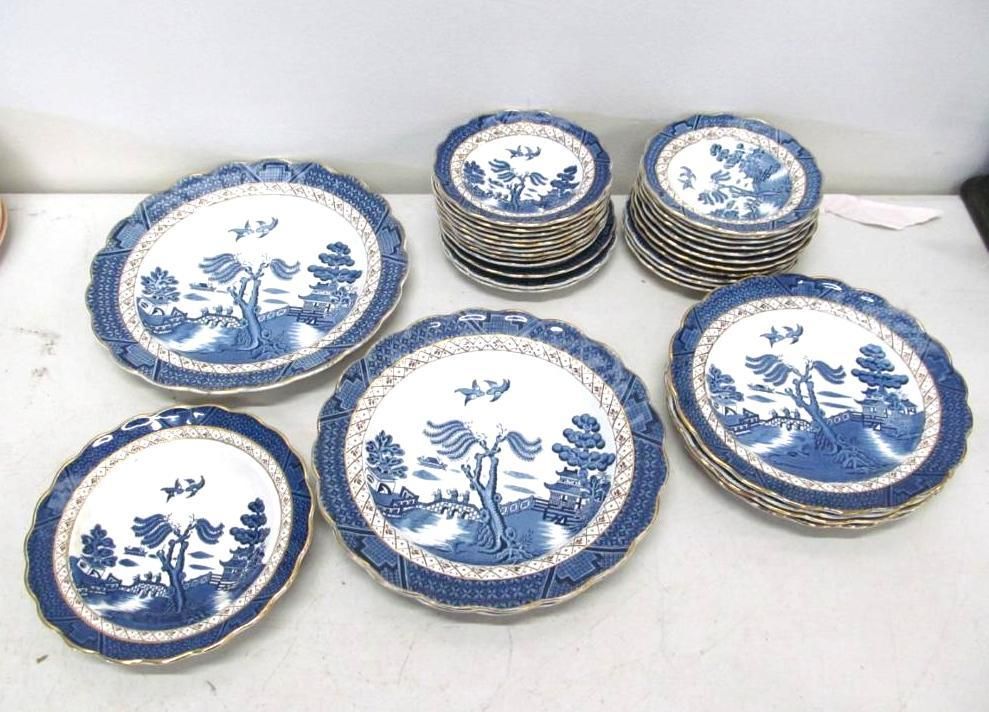 Blue and white patterned plates in various stacks and sizes, arranged on a surface.