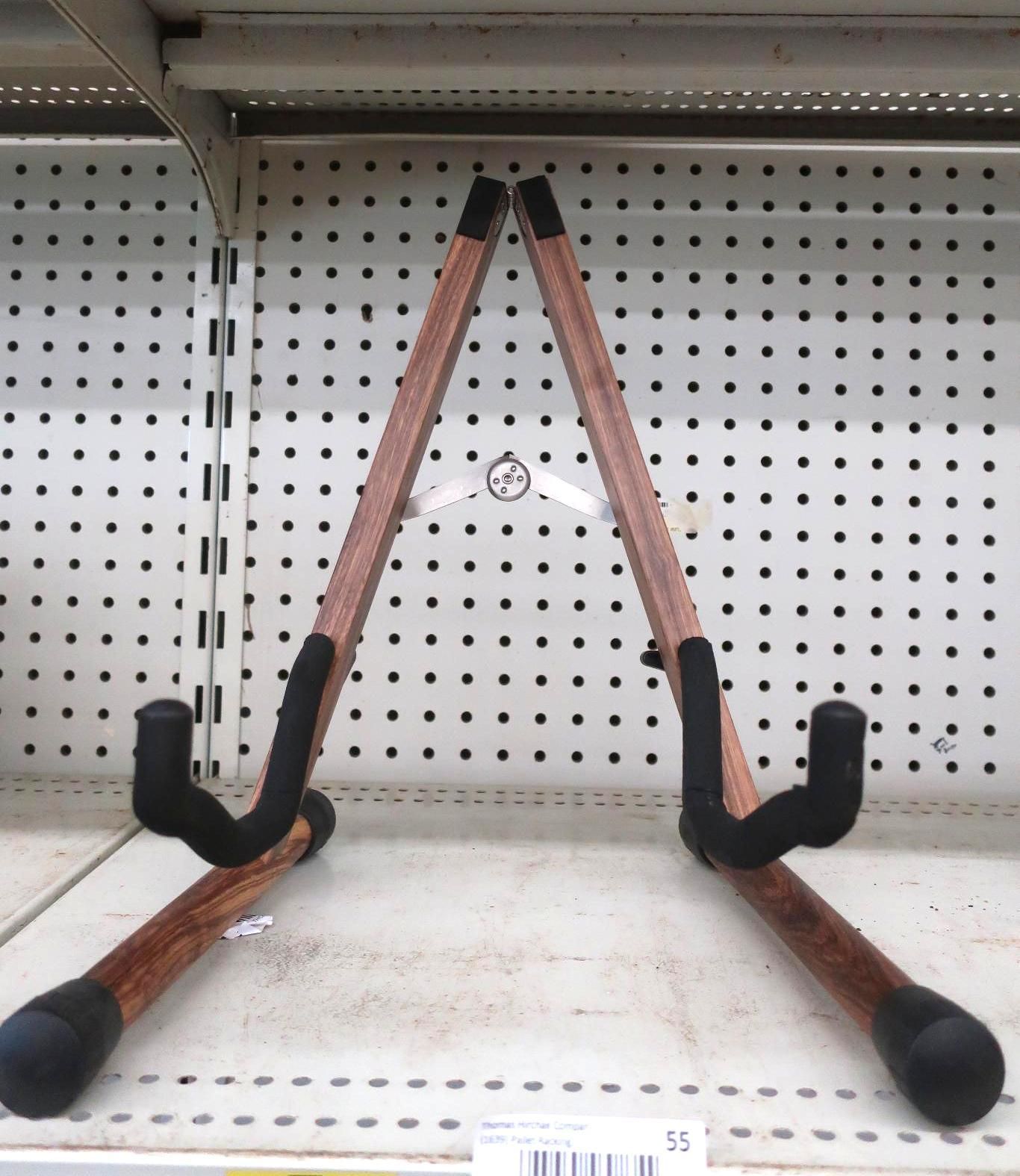 Wooden guitar stand on a shelf, with black supports.