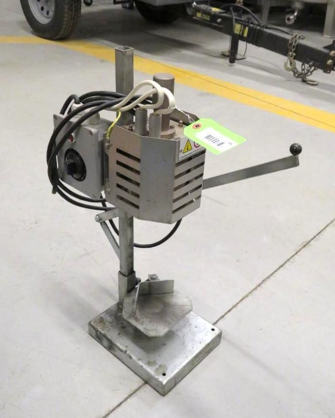 Stainless steel electric capping machine on a base, with a handle and power cord.