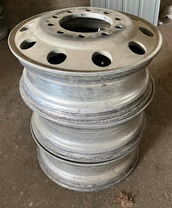 Three silver truck rims stacked on each other.