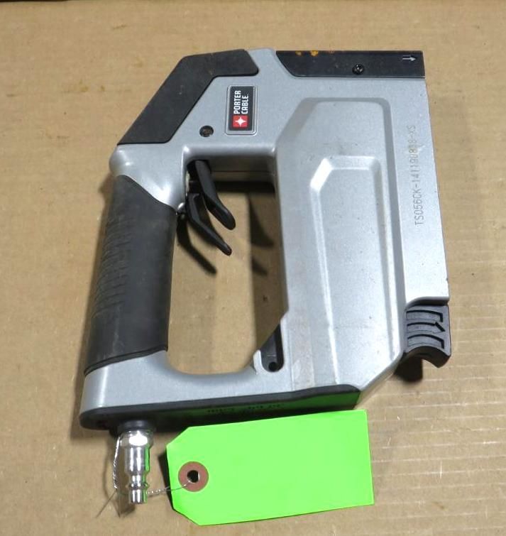 Silver and black pneumatic staple gun with a green tag.