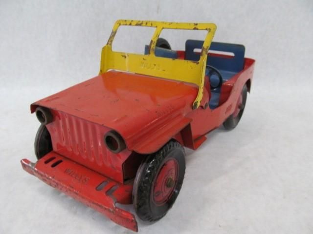 Red, yellow, and blue vintage toy jeep with black tires.
