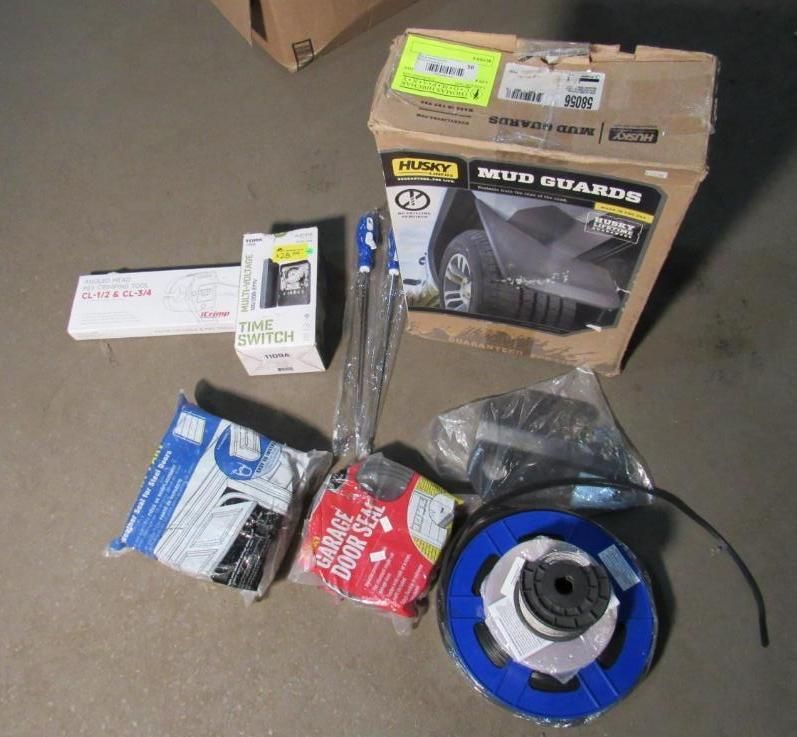 Various car accessories and home improvement items on a floor, including mud boards, garage door seal, and time switch.