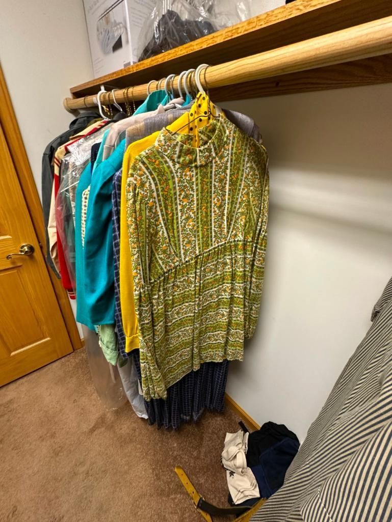 Clothes hanging in a closet; various colors, including green and yellow.