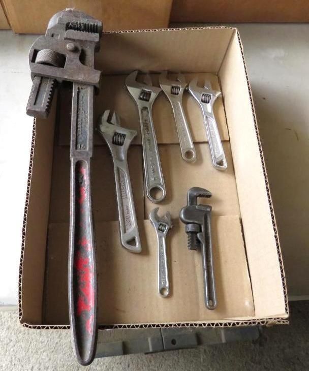 Box of adjustable wrenches, including a large pipe wrench.