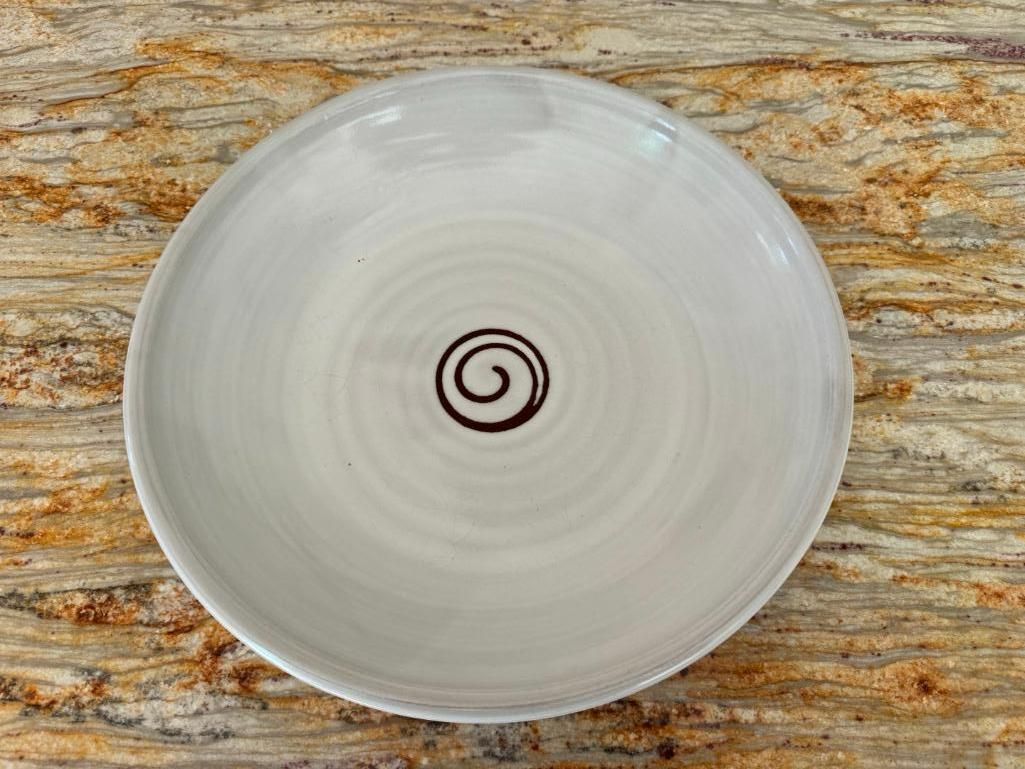White ceramic bowl with brown spiral design on a marbled surface.